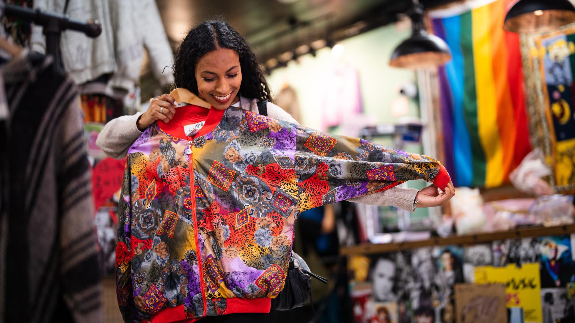 Woman holding up a jacket to herself in a store