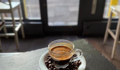 Espresso surrounded by coffee beans