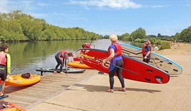 People putting paddleboards into the Thames