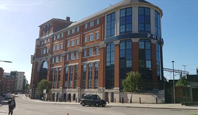 brick and glass office exterior with railway in background