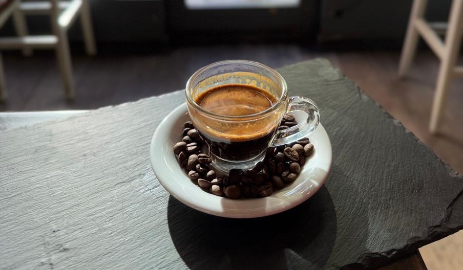 Espresso surrounded by coffee beans