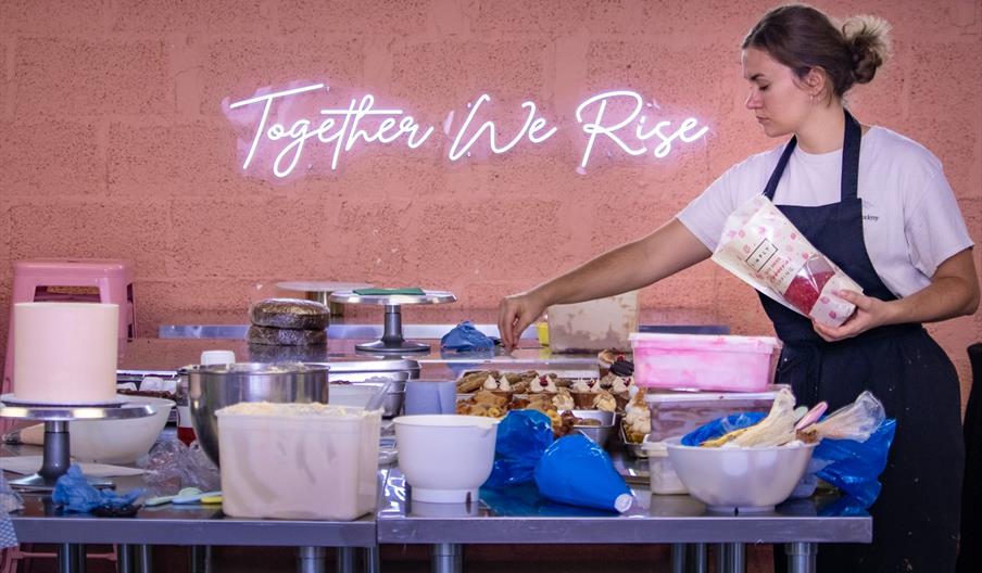 baker putting sweets on top of a cake