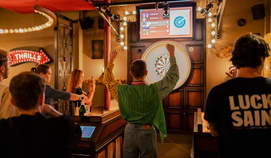 Man cheering with a dart board