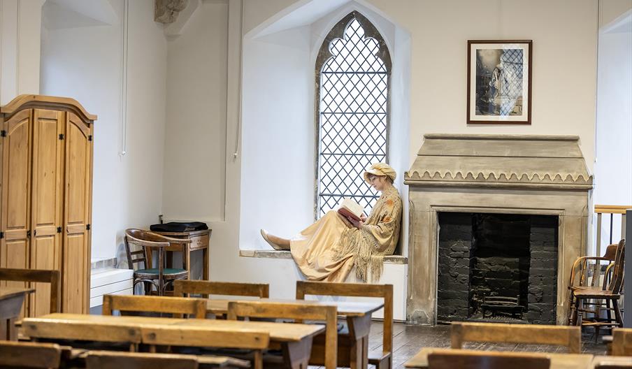 'Jane Austen' sitting in the window of her former schoolroom