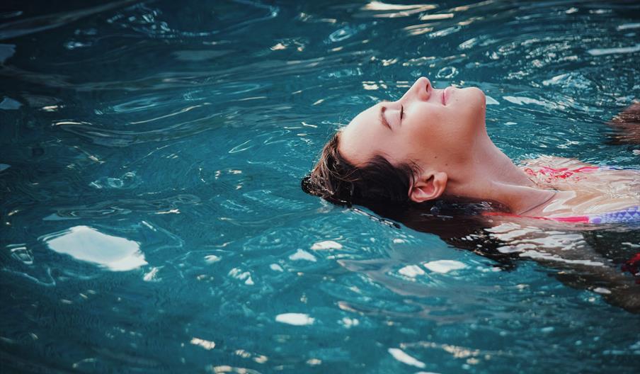 woman floating in pool