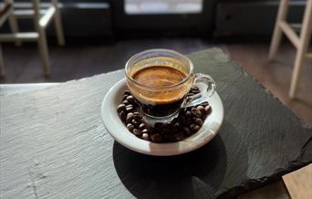 Espresso surrounded by coffee beans