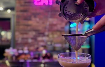 Straining a cocktail at the bar