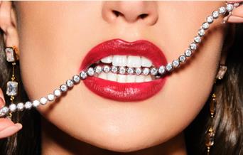 Woman wearing lipstick with jewellery in her mouth