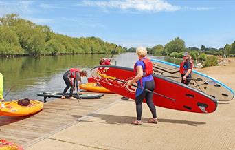 People putting paddleboards into the Thames