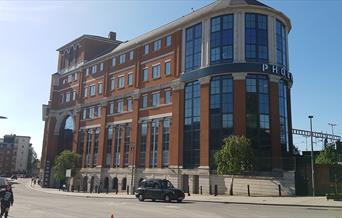 brick and glass office exterior with railway in background