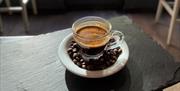 Espresso surrounded by coffee beans