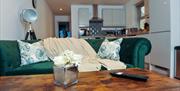 Green sofa with kitchen behind