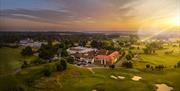 The photo shows a drone shot of the whole of the Estate. In the foreground, the golf course is visible with it's bunkers. Wokefield Place can also be