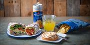 Wrap, sandwich, crisps, san pellegrino drink and a meringue dessert