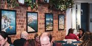 Art on the walls, customers sat at tables