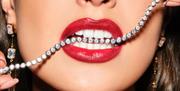 Woman wearing lipstick with jewellery in her mouth