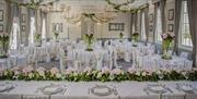 The photo shows the Lincoln Suite set up for a wedding breakfast with a top table and banqueting rounds.