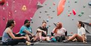 Group of 5 climbers with back to climbing wall