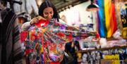 Woman holding up a brightly coloured jacket to herself