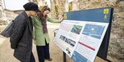 Visitors reading an interpretation panel in the Abbey Ruins