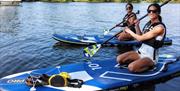 two women paddleboarding