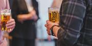 People holding pints of Siren beer