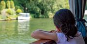 Girl looking out of a boat window