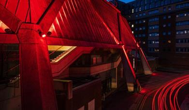 Night time outside the Hexagon with car lights