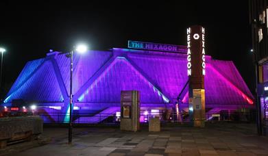 Night time outside the Hexagon with purple lights