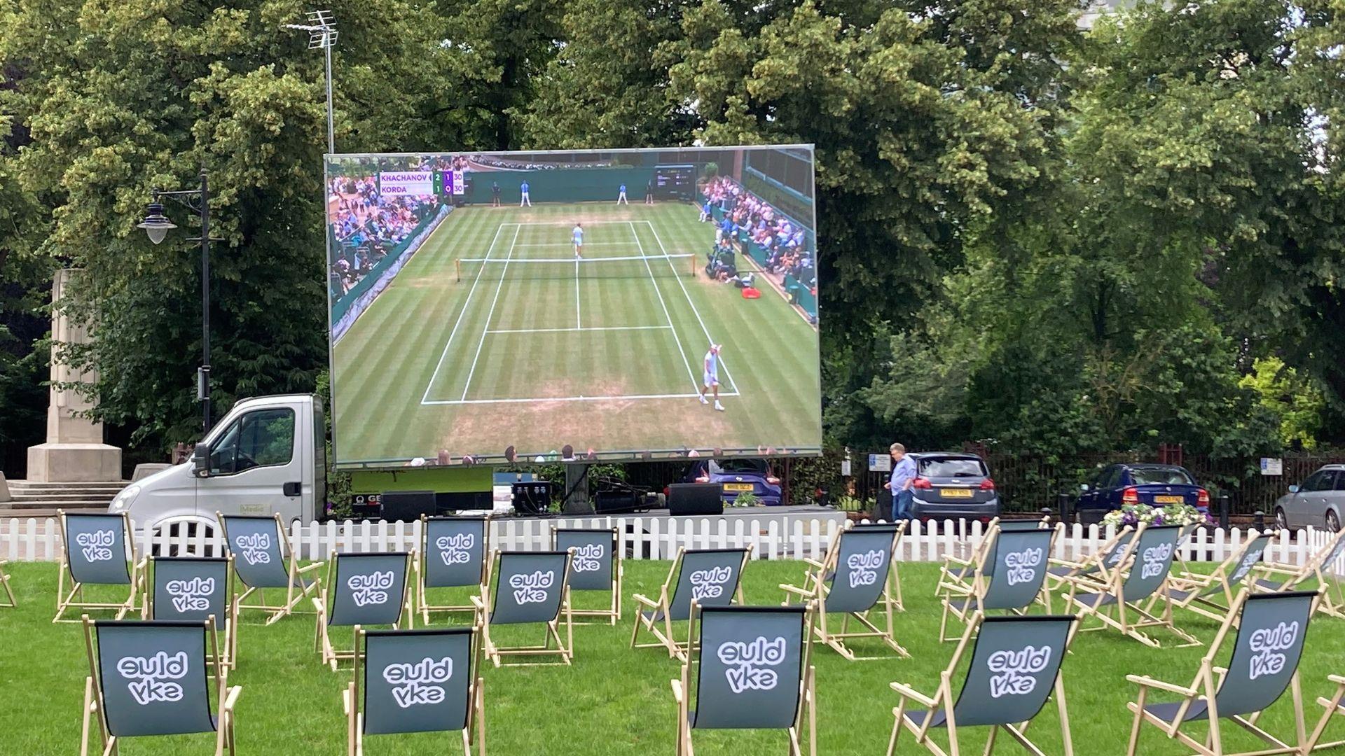 Deckchairs on lawn with Wimbledon tennis screening