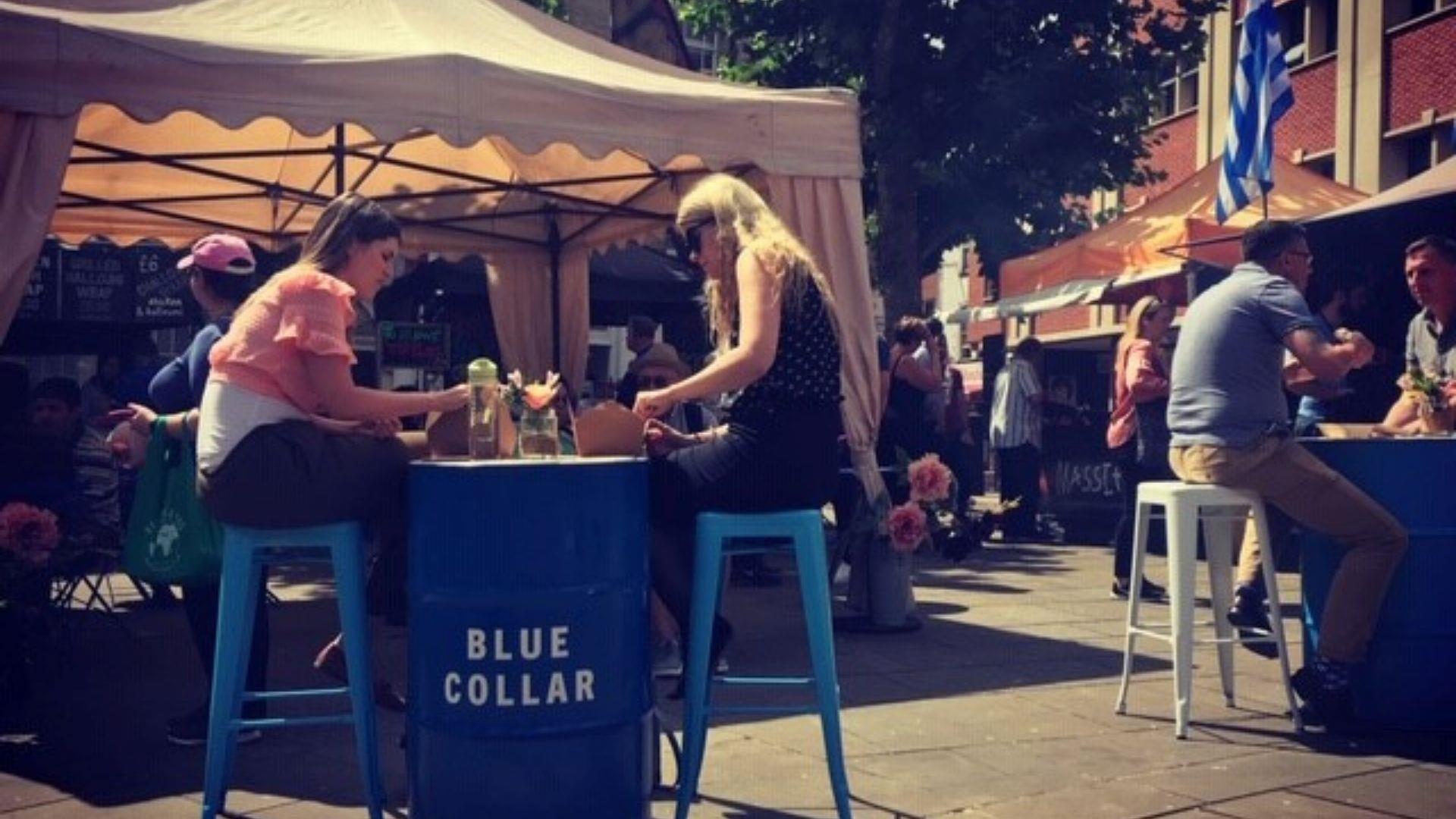 Two ladies eating street food at Blue Collar market in Reading