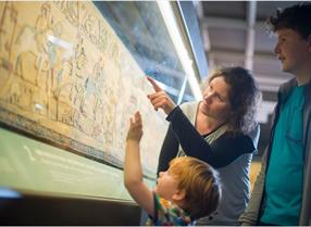 women and children looking at Bayeux Tapestry