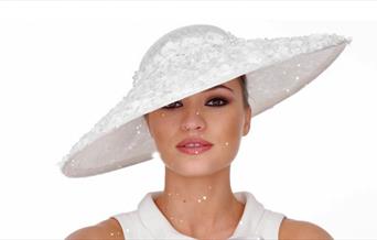 Model wearing a white wide brimmed hat by Adrienne Henry