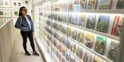 A visitor looks at a glass case displaying rows of Ladybird books