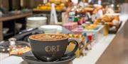 Mug with 'Ori Caffe' written on it in gold