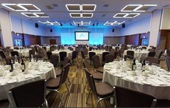 conference centre room with tables laid for event