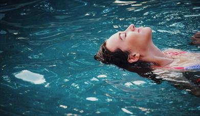 woman floating in pool
