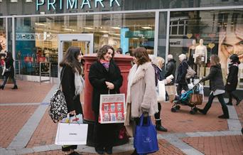 3 shoppers stood in front of Primark