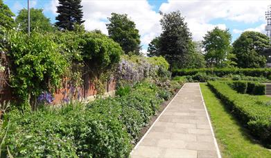 A neatly kept path and flower bed at Denehurst Park.