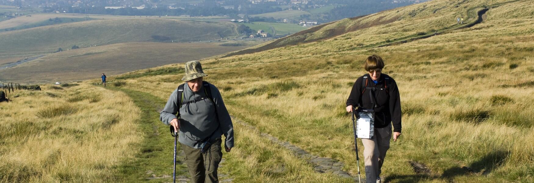 A couple hiking up a hill.