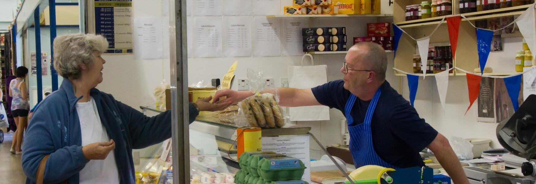 A market trader serving a customer at Heywood Market.