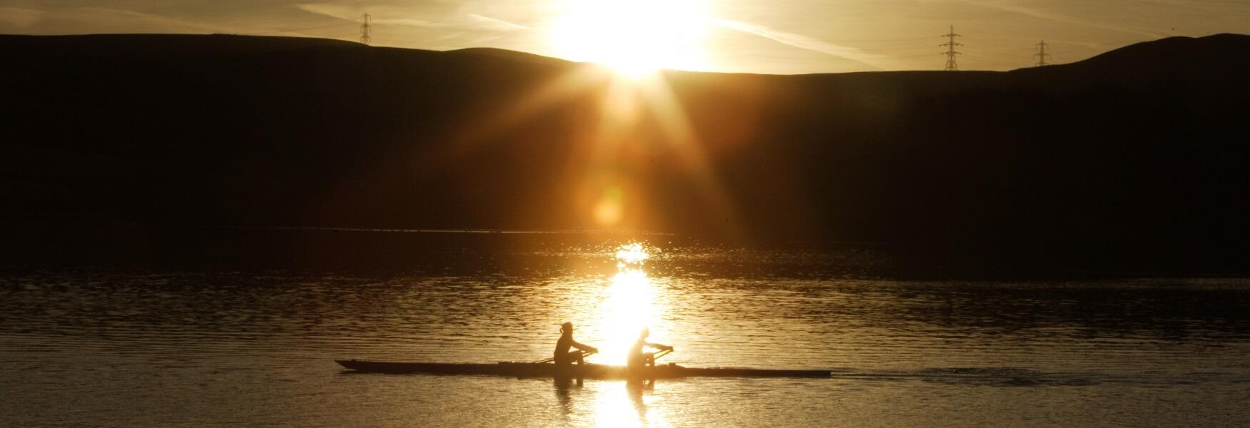 A rowing boat on Hollingworth Lake at sunset.
