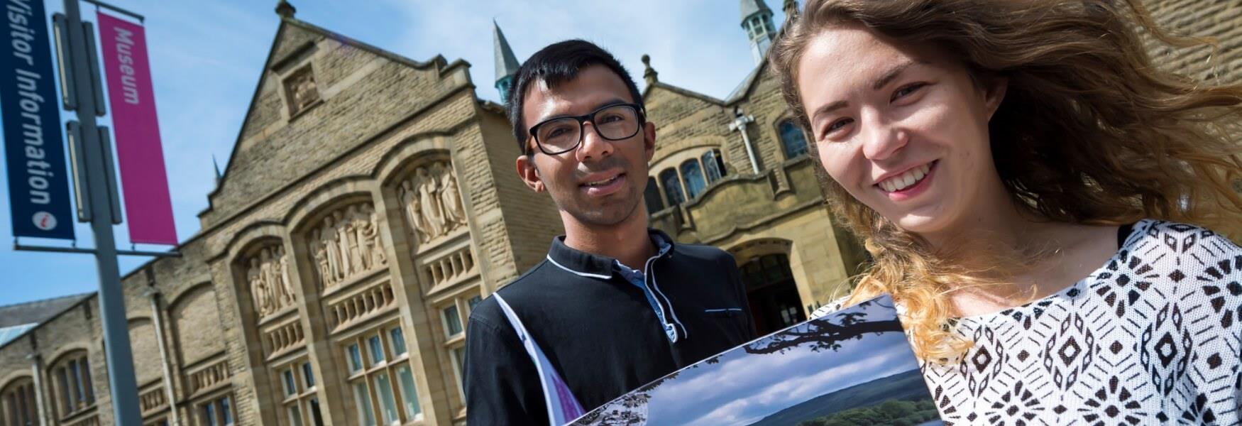 A smiling couple in front of Touchstones Rochdale.