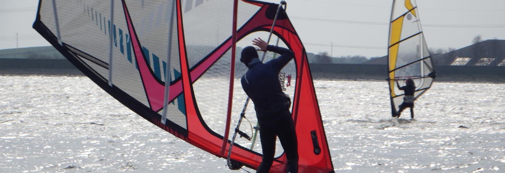 A lone windsurfer on Hollingworth Lake.