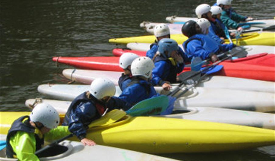 Row of People in Canoes