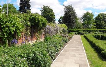 A neatly kept path and flower bed at Denehurst Park.