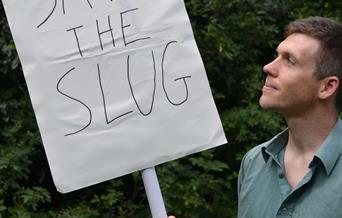 Simon Watt holding a sign saying "Save the Slug".
