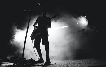 Musician on stage with white backlight