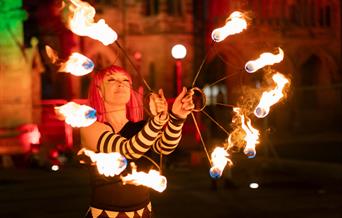 Performer with lit torches.