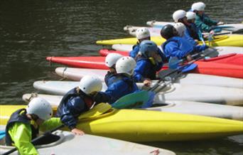 Row of People in Canoes